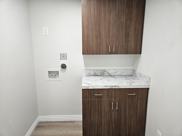 laundry room featuring cabinet space, washer hookup, baseboards, and wood finished floors