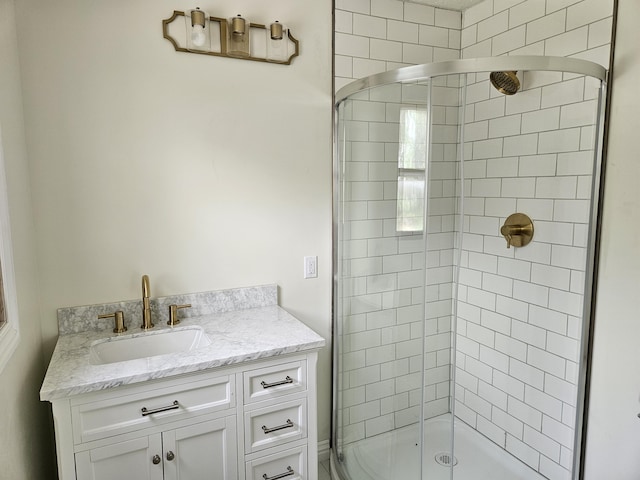bathroom with tiled shower and vanity