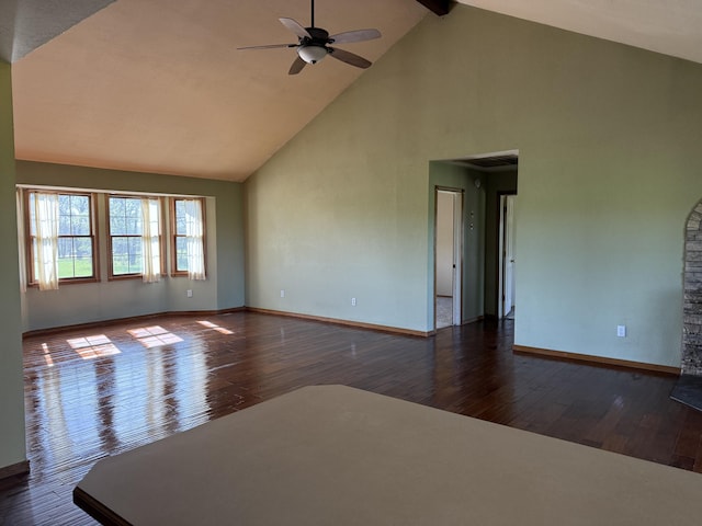 empty room featuring baseboards, a ceiling fan, wood finished floors, and high vaulted ceiling