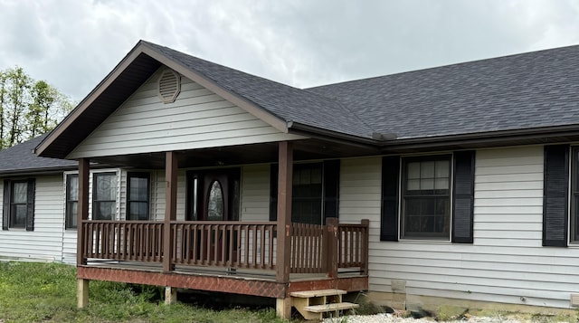 view of front of house with covered porch and a shingled roof
