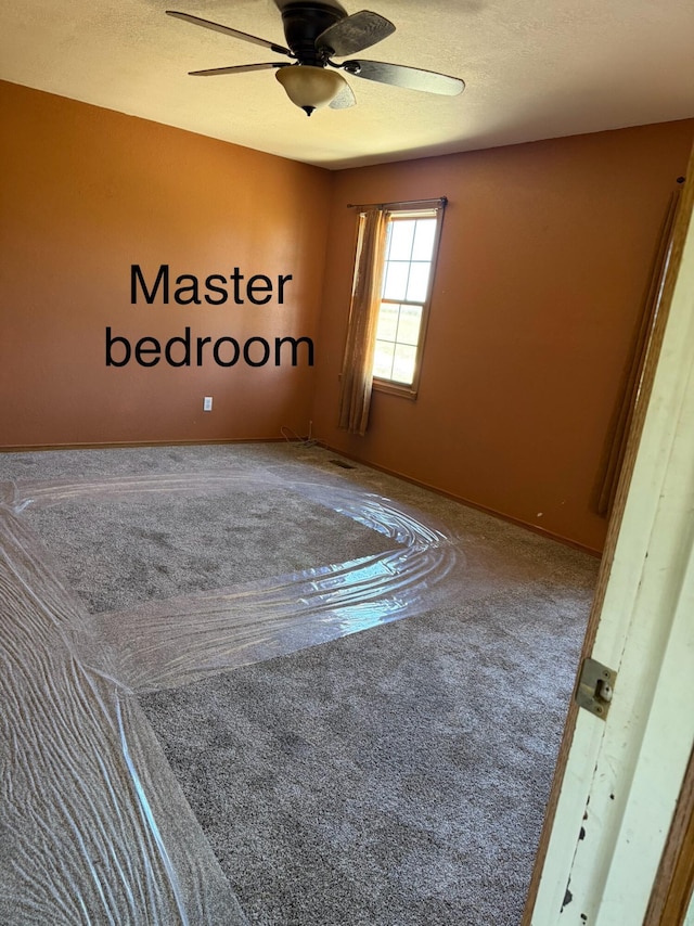 empty room with a ceiling fan and carpet flooring