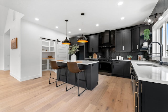 1822 E Cobblestone Dr, Ozark, MO 65721 - kitchen with wall chimney range hood, a sink, black gas range oven, a barn door, and decorative backsplash