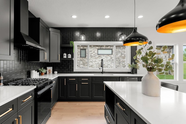 1822 E Cobblestone Dr, Ozark, MO 65721 - kitchen featuring black range with gas cooktop, a sink, wall chimney range hood, light countertops, and decorative backsplash