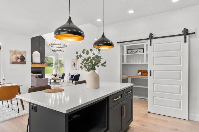 1822 E Cobblestone Dr, Ozark, MO 65721 - kitchen featuring light wood-type flooring, light countertops, a barn door, recessed lighting, and pendant lighting