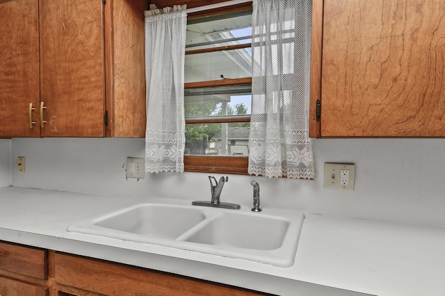 details with light countertops, brown cabinets, and a sink