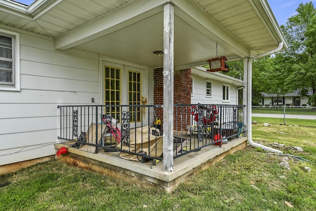 wooden terrace featuring a porch, fence, and a yard