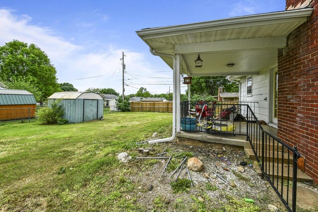 view of yard with a storage unit, an outdoor structure, and fence