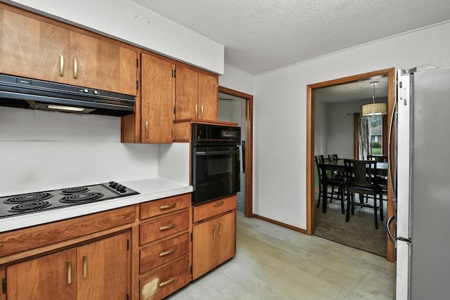 kitchen featuring brown cabinetry, light countertops, a textured ceiling, under cabinet range hood, and black appliances
