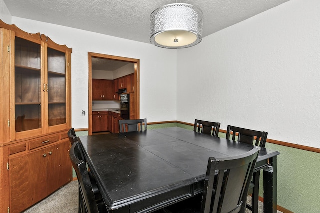 dining area with a textured wall and a textured ceiling