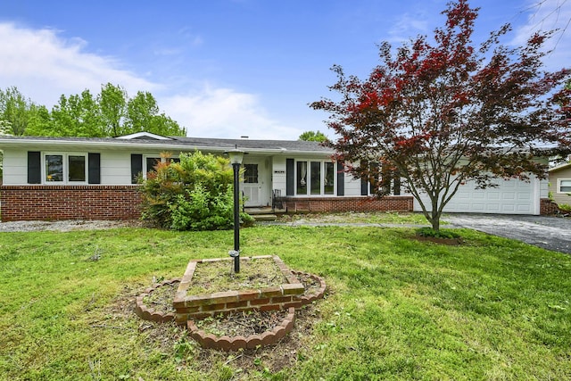 single story home with a garage, driveway, a front lawn, and brick siding