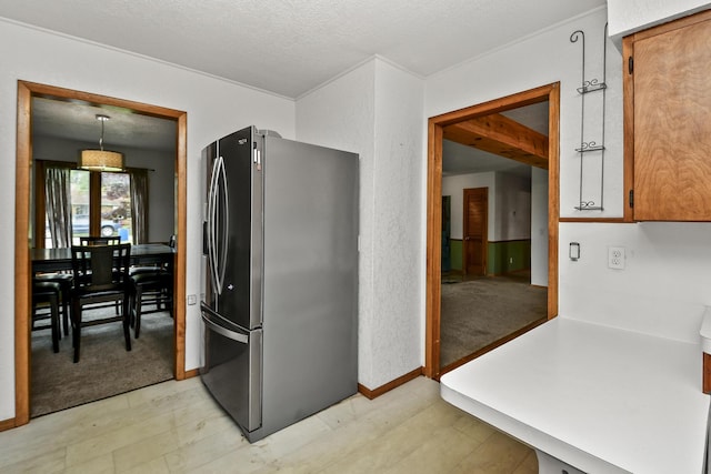 kitchen with light colored carpet, stainless steel fridge, light countertops, a textured ceiling, and light floors