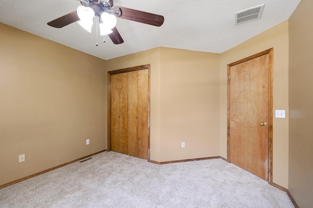 unfurnished bedroom with visible vents, carpet flooring, and ceiling fan