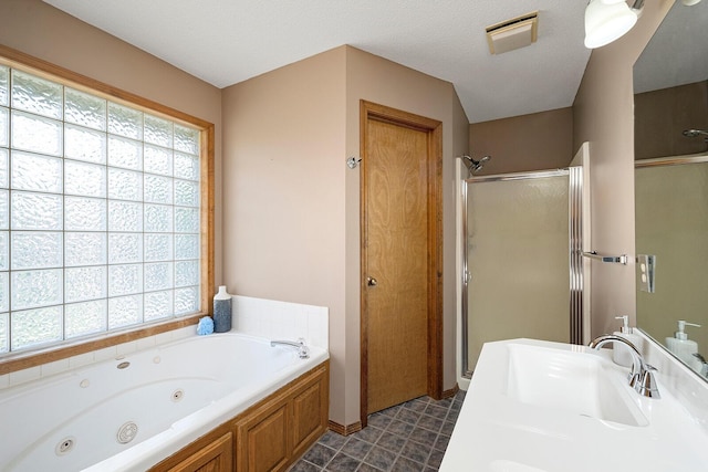 bathroom with a whirlpool tub, a wealth of natural light, a sink, and a stall shower