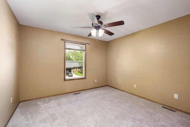 carpeted empty room featuring a ceiling fan, baseboards, and visible vents