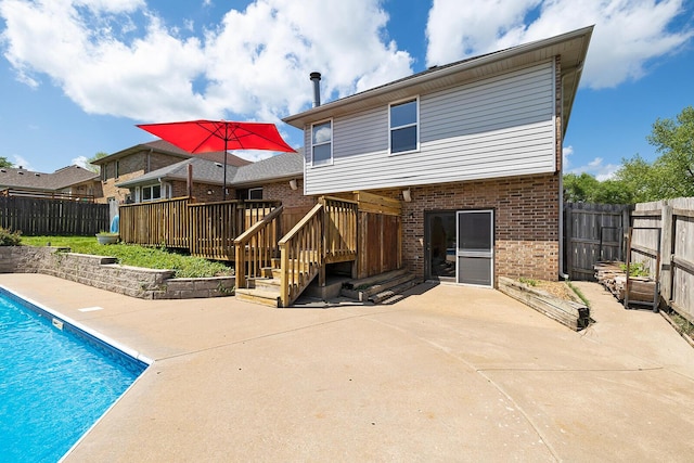 back of property featuring a fenced backyard, a patio, and brick siding