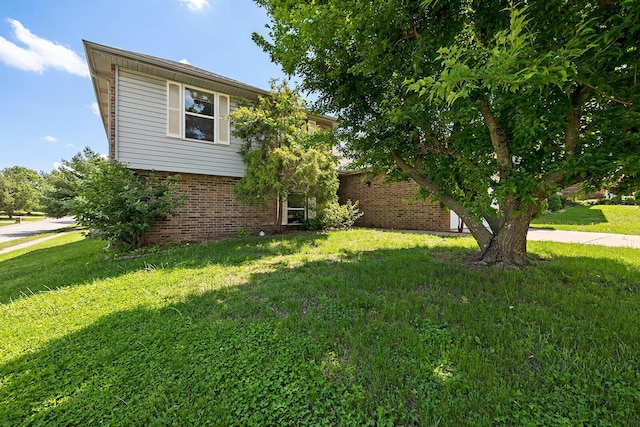 view of property exterior with a yard and brick siding