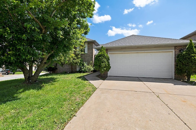 view of front of house with roof with shingles, an attached garage, brick siding, a front yard, and concrete driveway