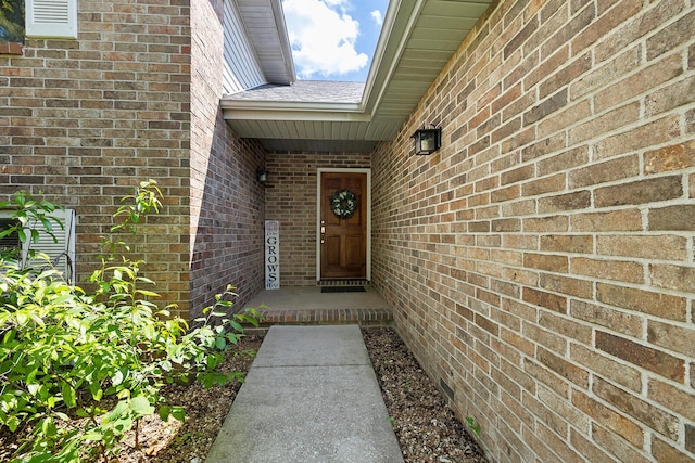 entrance to property featuring brick siding