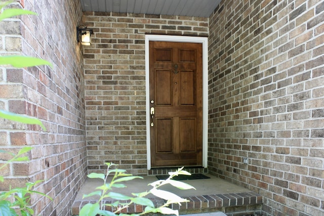 view of exterior entry with brick siding