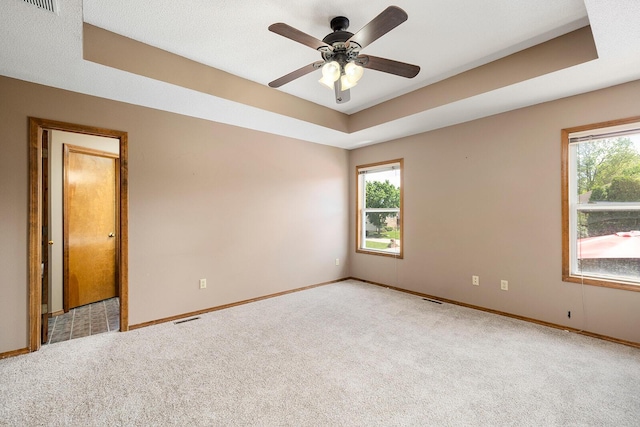 empty room with baseboards, ceiling fan, a healthy amount of sunlight, and carpet