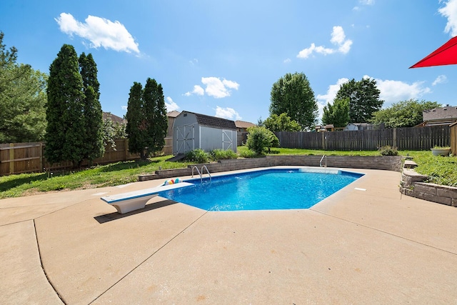 view of swimming pool with a fenced backyard, a storage unit, a patio, and an outbuilding