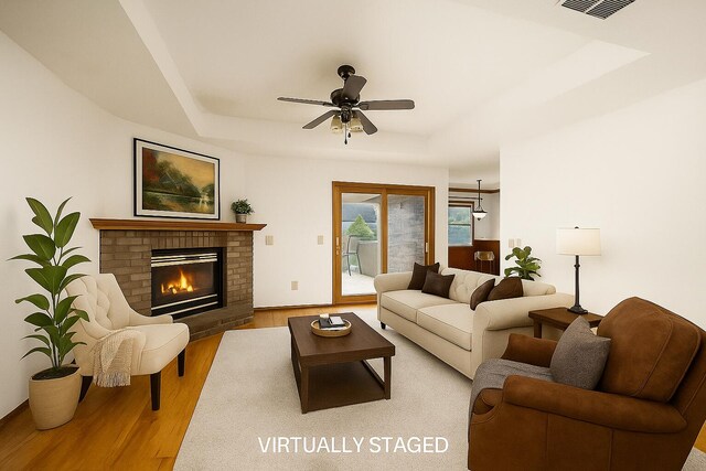 3934 W Lark St, Springfield, MO 65810 - living area with a raised ceiling, wood finished floors, ceiling fan, and a fireplace