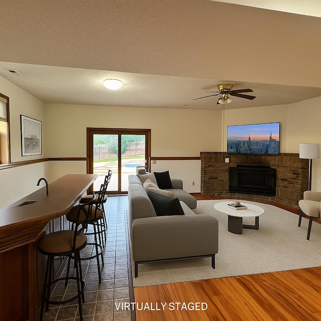 3934 W Lark St, Springfield, MO 65810 - living area with a fireplace, ceiling fan, and wood finished floors