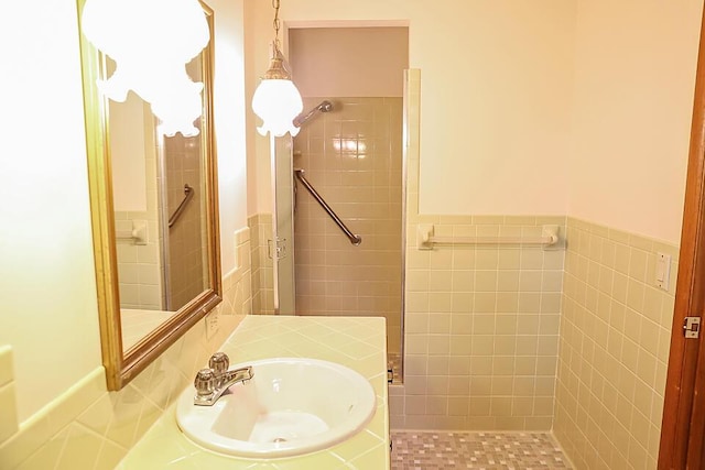 706 W Katella Ct, Springfield, MO 65807 - bathroom with a sink, tile walls, a wainscoted wall, and a tile shower