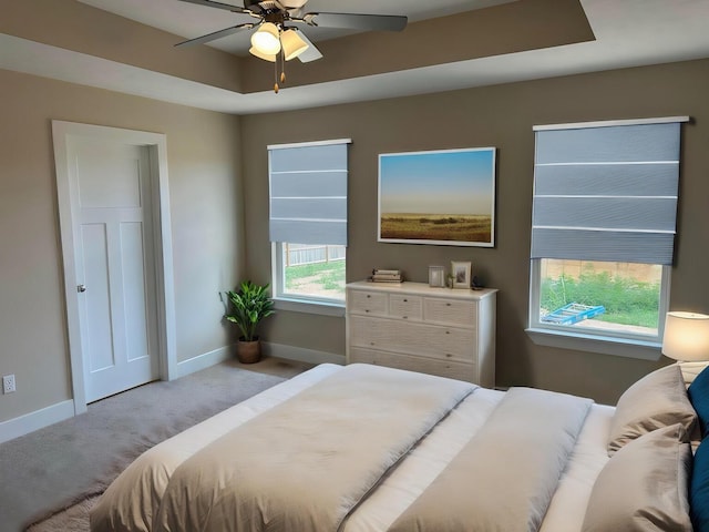 bedroom with a ceiling fan, baseboards, and carpet