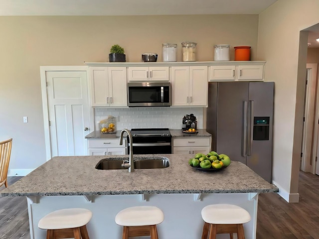 kitchen featuring a sink, appliances with stainless steel finishes, white cabinets, and dark wood finished floors