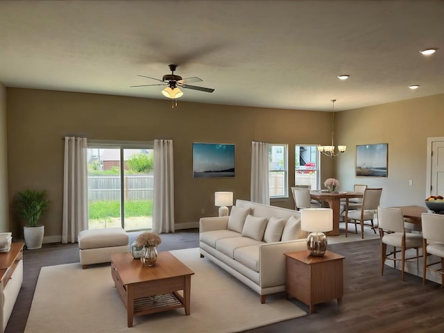 living room with recessed lighting, baseboards, ceiling fan with notable chandelier, and dark wood-style flooring