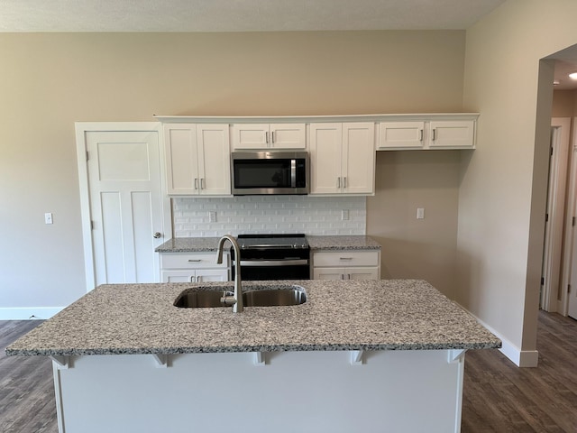 kitchen featuring white cabinets, electric range, a sink, baseboards, and stainless steel microwave