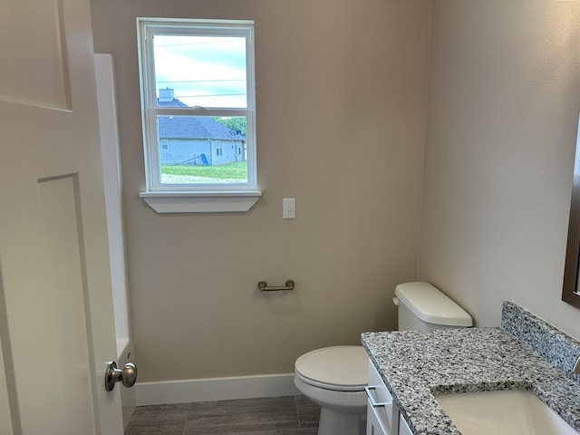 bathroom featuring baseboards, vanity, and toilet