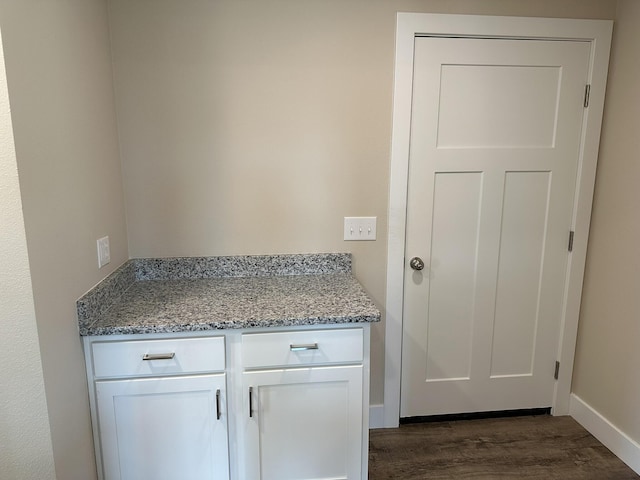 interior space with baseboards and dark wood finished floors
