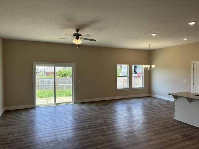 unfurnished living room featuring baseboards, a textured ceiling, and ceiling fan with notable chandelier