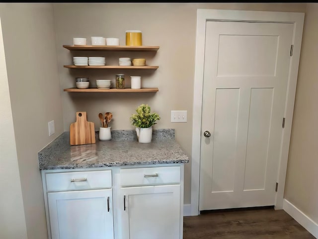 bar featuring baseboards and dark wood-type flooring