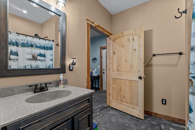 bathroom with a shower with curtain, concrete floors, baseboards, and vanity