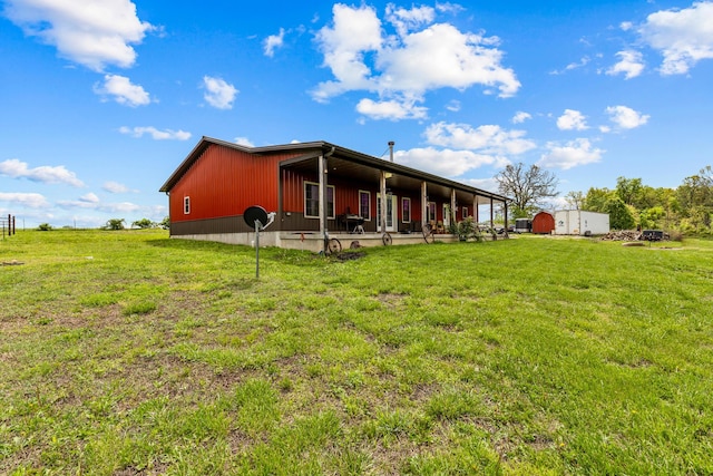 rear view of property featuring an outbuilding and a yard