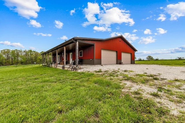 exterior space with a lawn, a garage, and an outbuilding