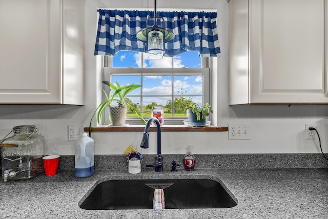 kitchen featuring a sink and white cabinets