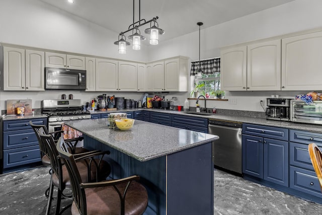 kitchen featuring a sink, appliances with stainless steel finishes, a breakfast bar area, and blue cabinetry
