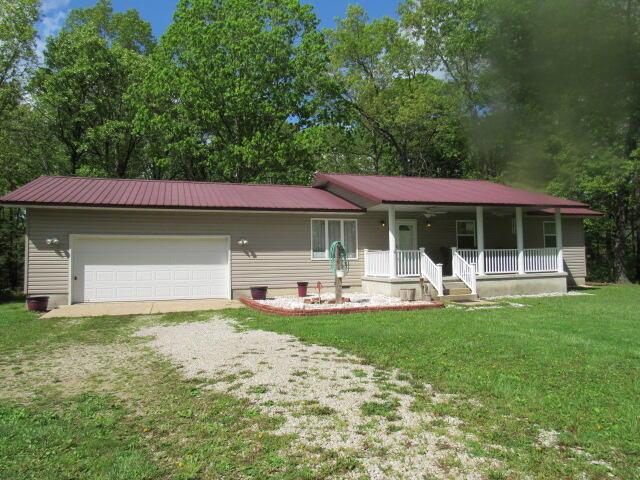 7210 Newkirk Rd, Mountain Grove, MO 65711 - single story home featuring a porch, dirt driveway, metal roof, and a front lawn