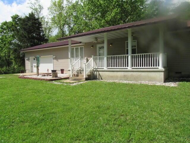 7210 Newkirk Rd, Mountain Grove, MO 65711 - single story home featuring a porch, a front lawn, a garage, and crawl space