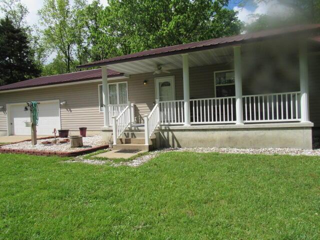 7210 Newkirk Rd, Mountain Grove, MO 65711 - ranch-style home featuring a porch, an attached garage, and a front yard