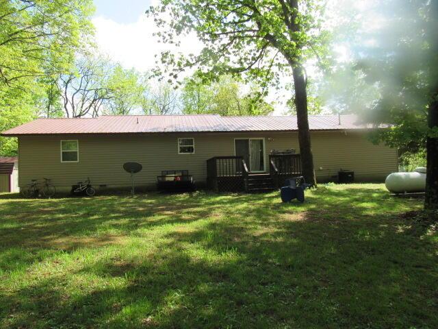 7210 Newkirk Rd, Mountain Grove, MO 65711 - rear view of house with metal roof, a deck, and a lawn