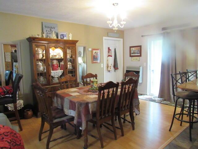 7210 Newkirk Rd, Mountain Grove, MO 65711 - dining area with light wood-style flooring and a notable chandelier