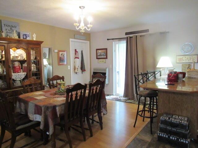 7210 Newkirk Rd, Mountain Grove, MO 65711 - dining space featuring heating unit, wood finished floors, and a notable chandelier