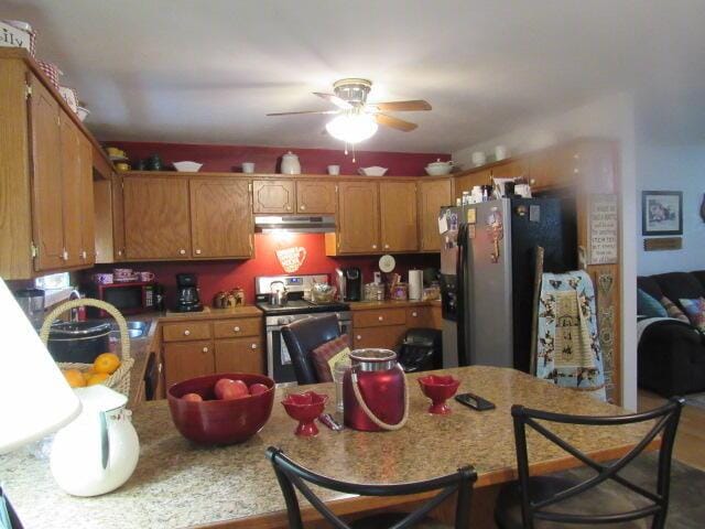 7210 Newkirk Rd, Mountain Grove, MO 65711 - kitchen with a peninsula, under cabinet range hood, light countertops, a ceiling fan, and appliances with stainless steel finishes