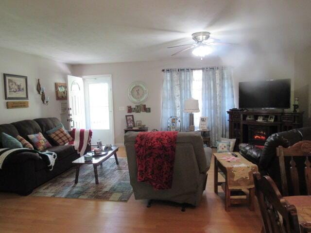7210 Newkirk Rd, Mountain Grove, MO 65711 - living area with a ceiling fan, a lit fireplace, and wood finished floors