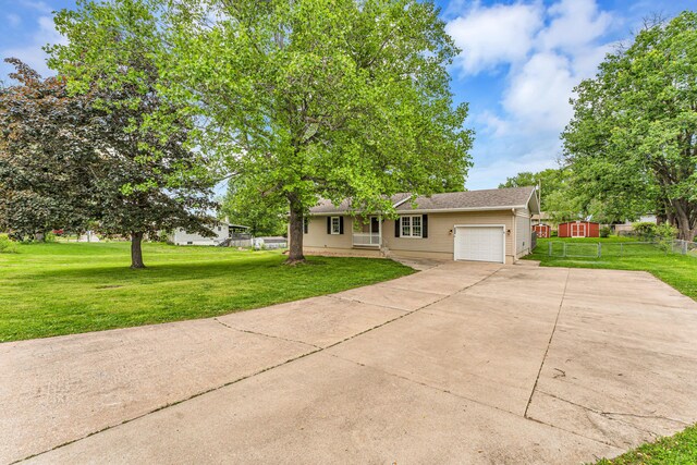 1107 E Mccracken Rd, Ozark, MO 65721 - ranch-style house with a front yard, fence, a garage, and driveway